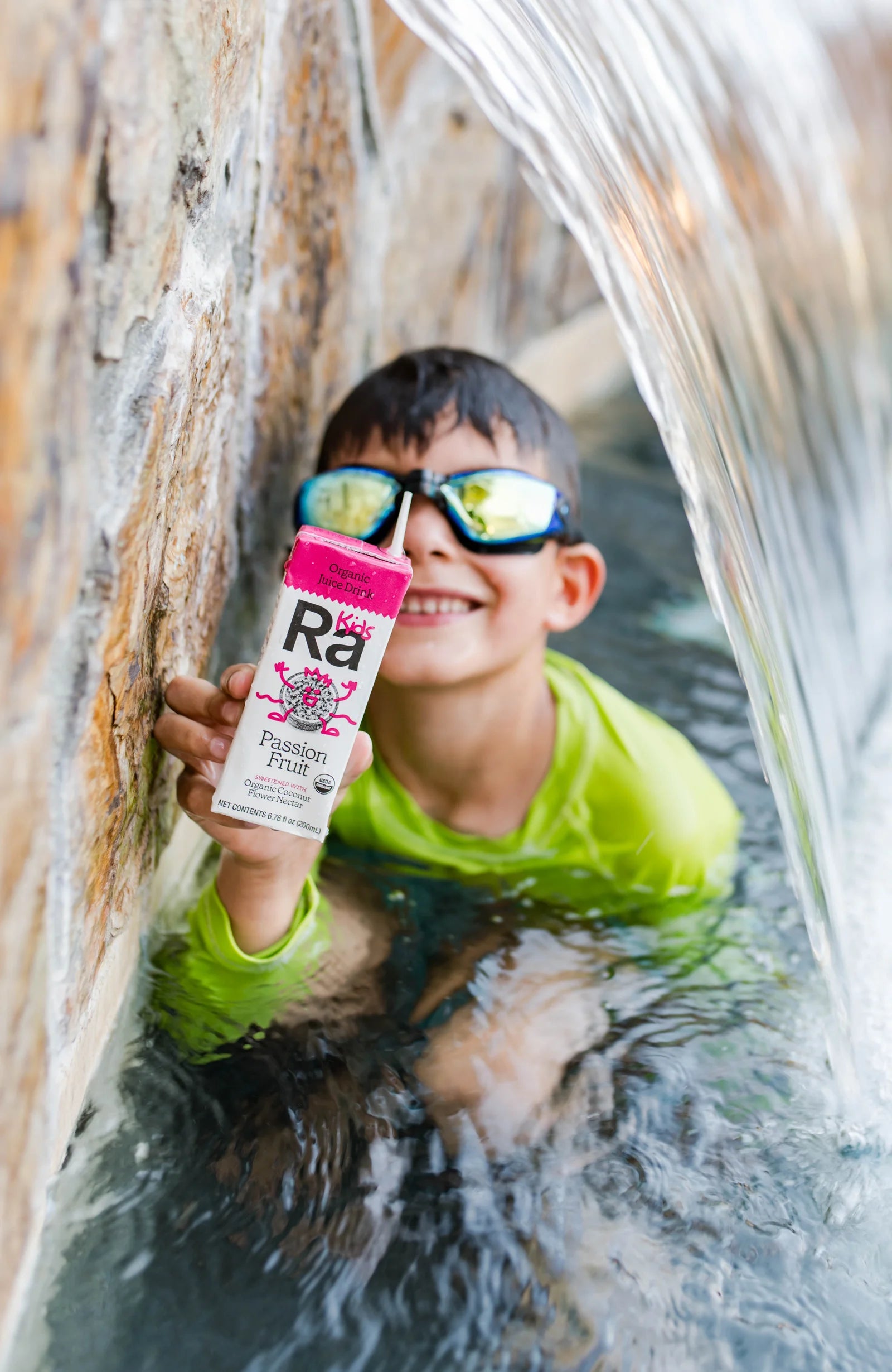 Child holding Ra Kids Passion Fruit by the pool